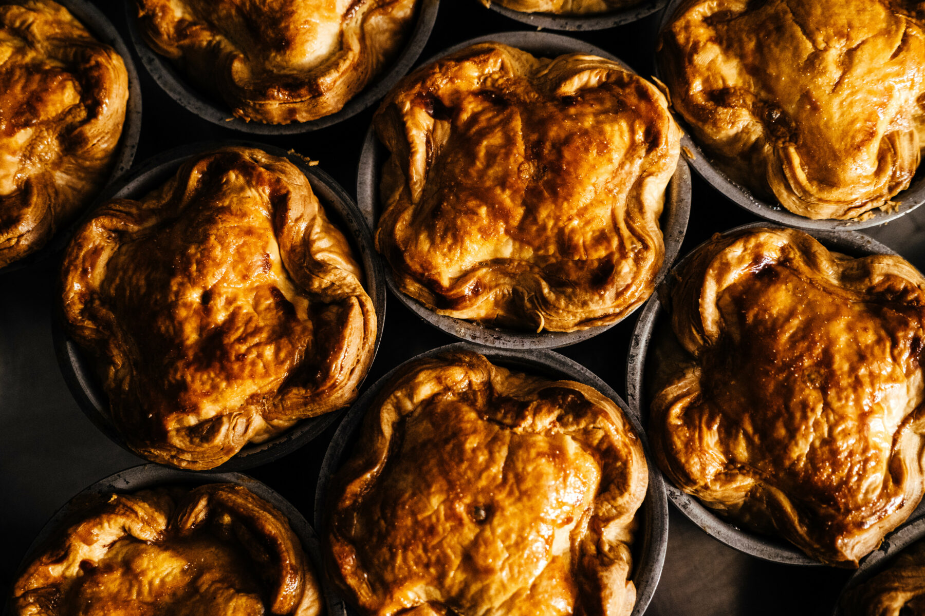 Tom's golden brown British Pie Award entries in baking tins.